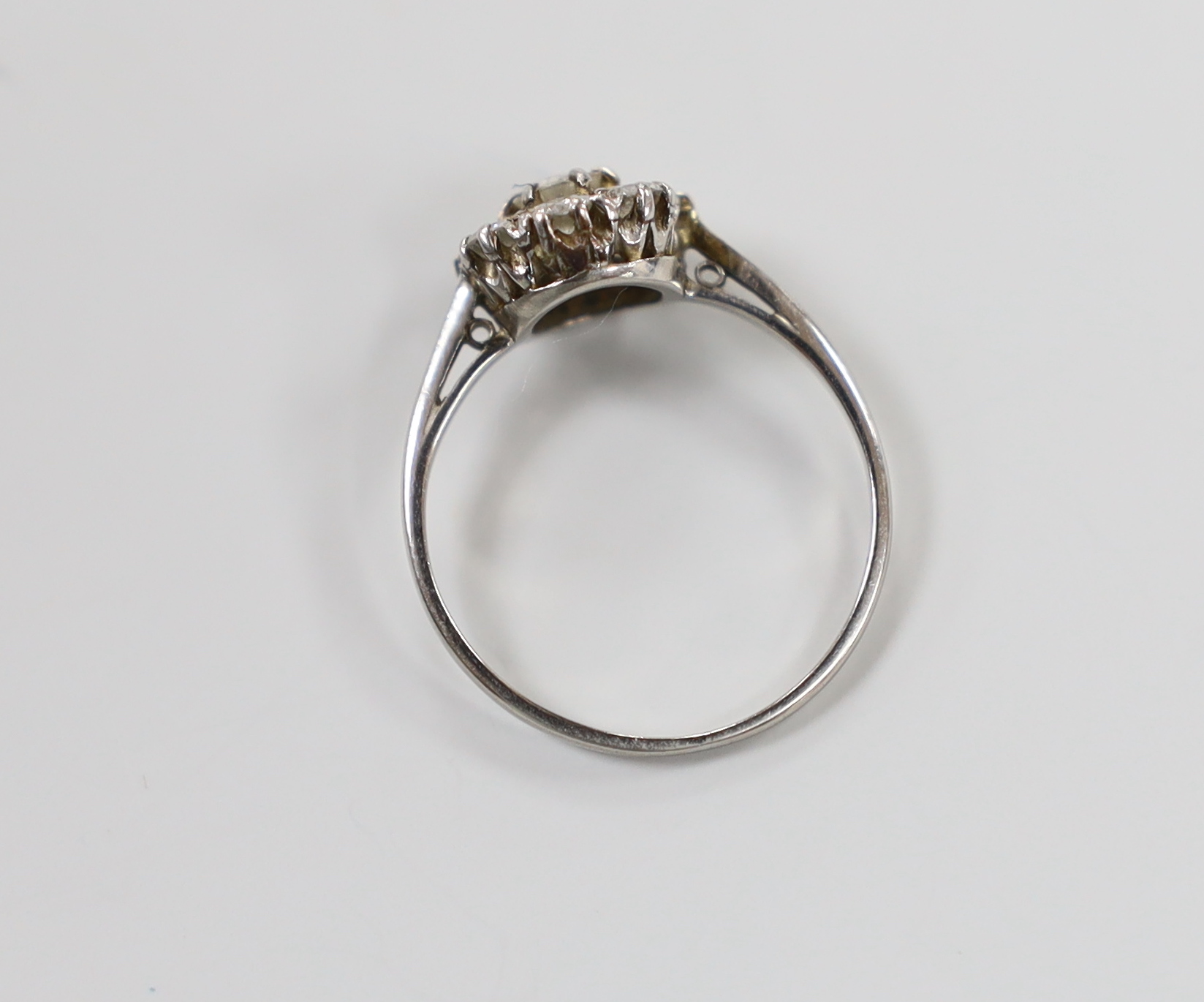 A white metal (stamped platinum) and eight stone diamond set flower head cluster ring, size M/N, gross weight 2.7 grams, (a.f.).